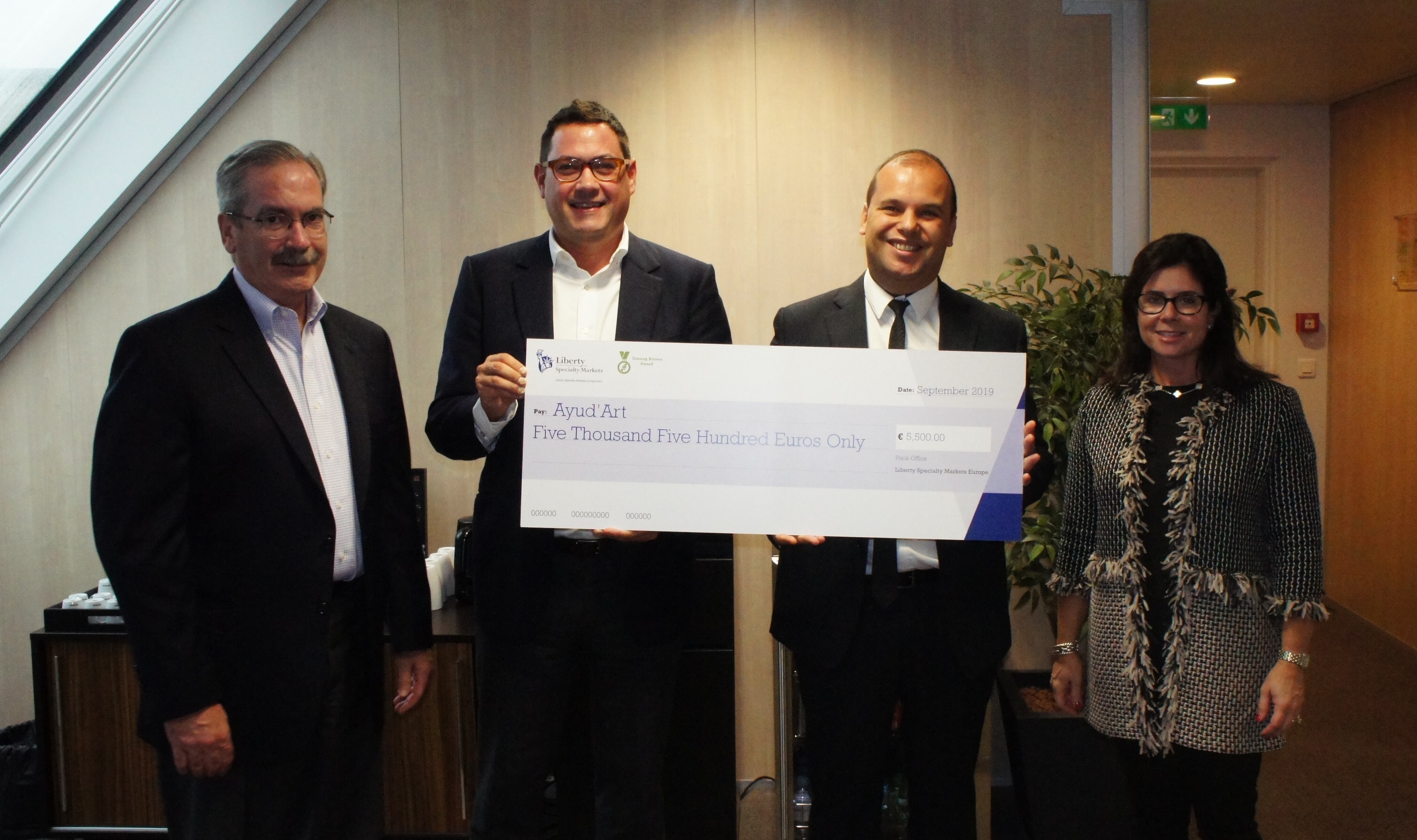 Four people - holding large cheque