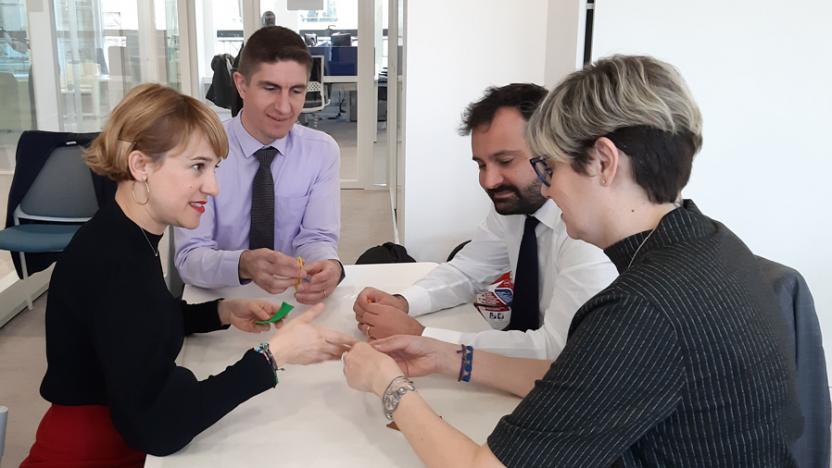 four people at a desk in discussion